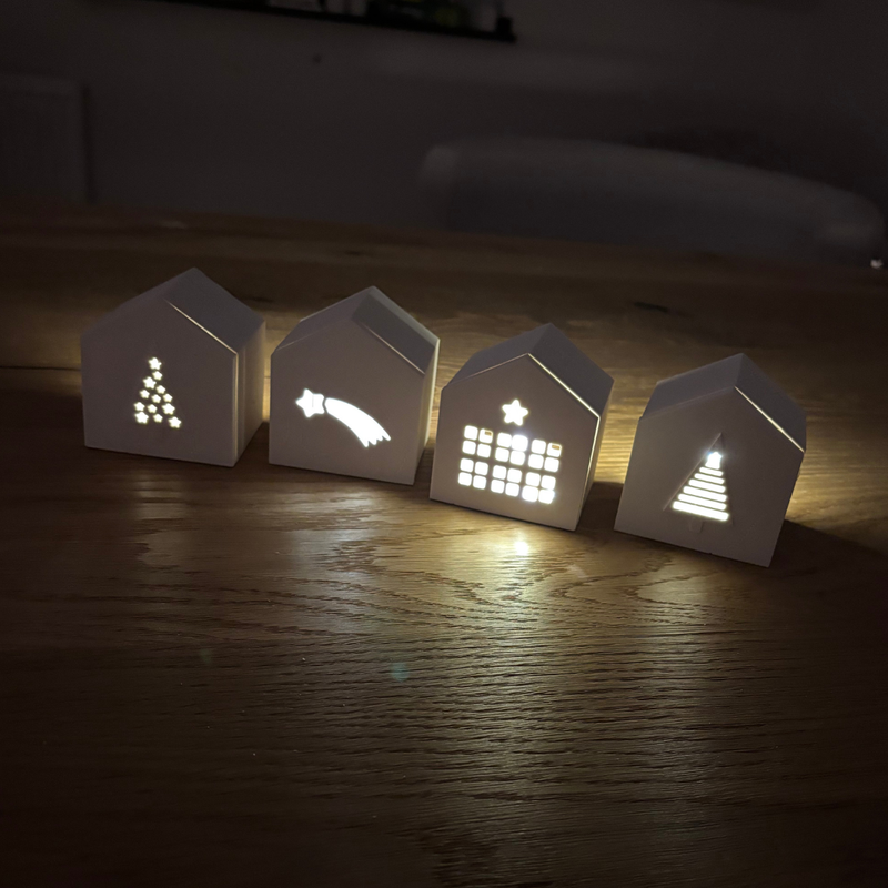 leuchtende Lichthäuserr mit Tannen, Sternschnuppe und Häuschen 